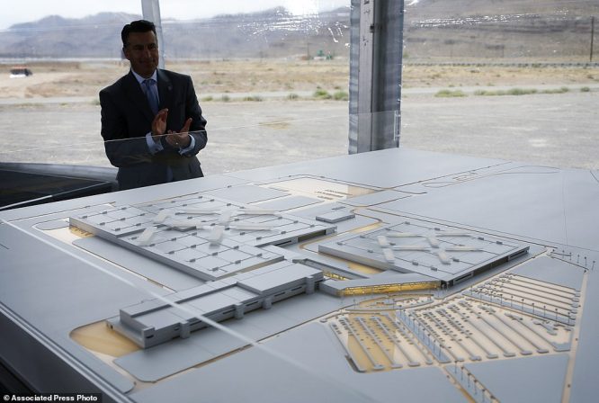 Nevada Gov. Brian Sandoval looks at a model for a Faraday Future factory, Wednesday, April 13, 2016, in North Las Vegas, Nev. The upstart electric car company held an event to mark the start of construction at a Las Vegas-area production plant toward which Nevada had pledged up to $335 million worth of incentives. (AP Photo/John Locher)